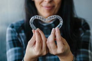 Patient making a Heart Shape with Dental Aligners